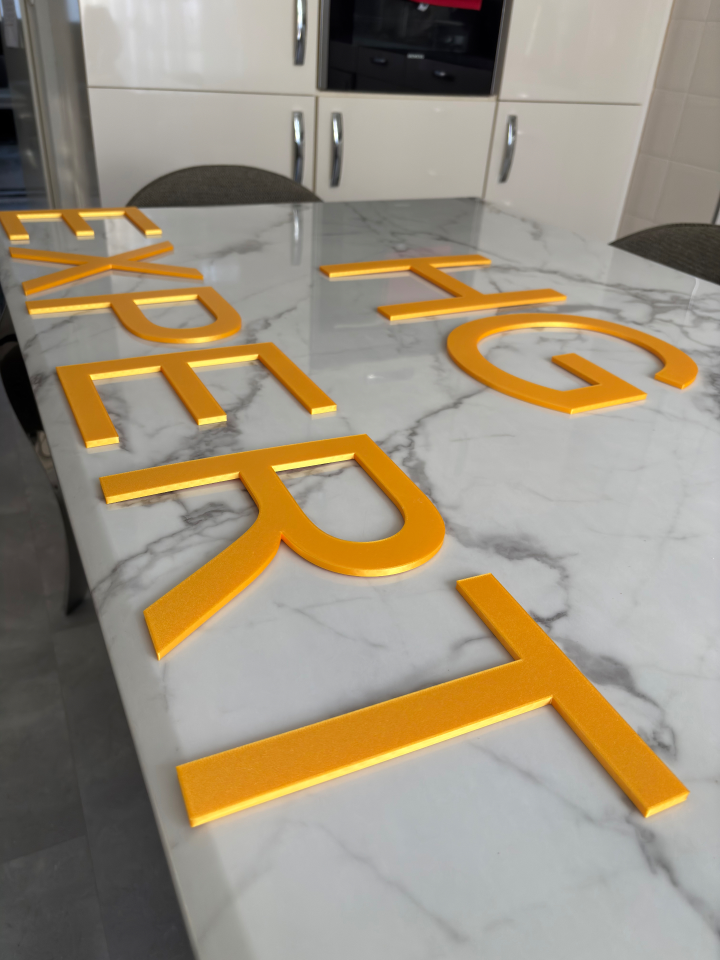Oranje kunststof letters op maat op een tafel